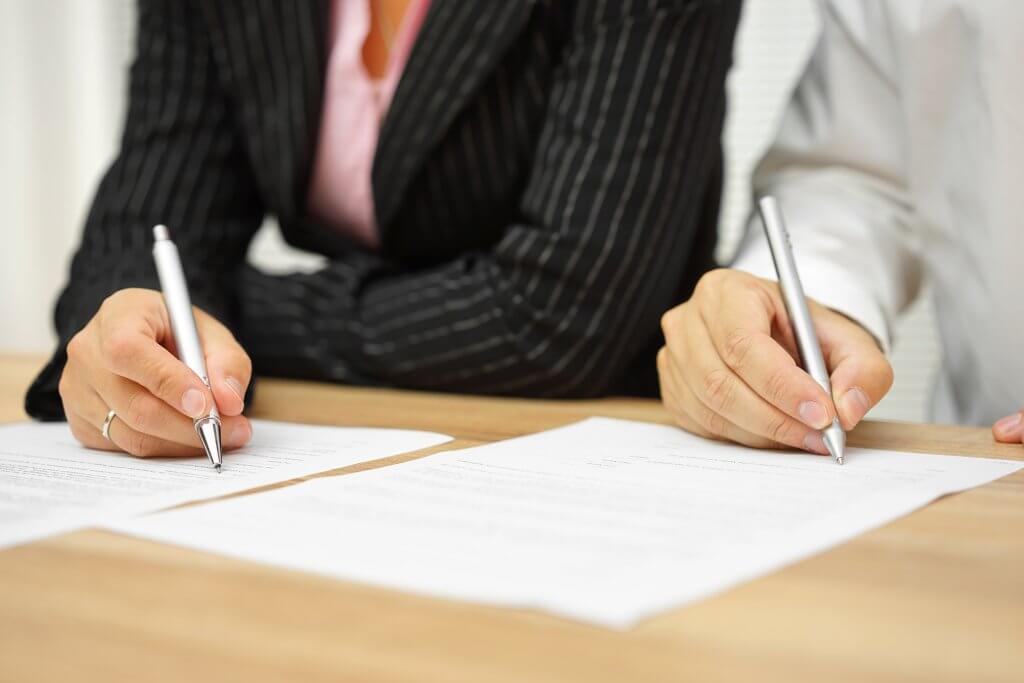 businesswoman and businessman signing contract