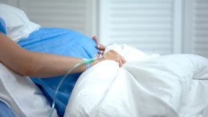 Pregnant woman holding blanket,