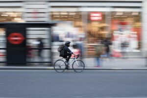 man cycling past London underground station